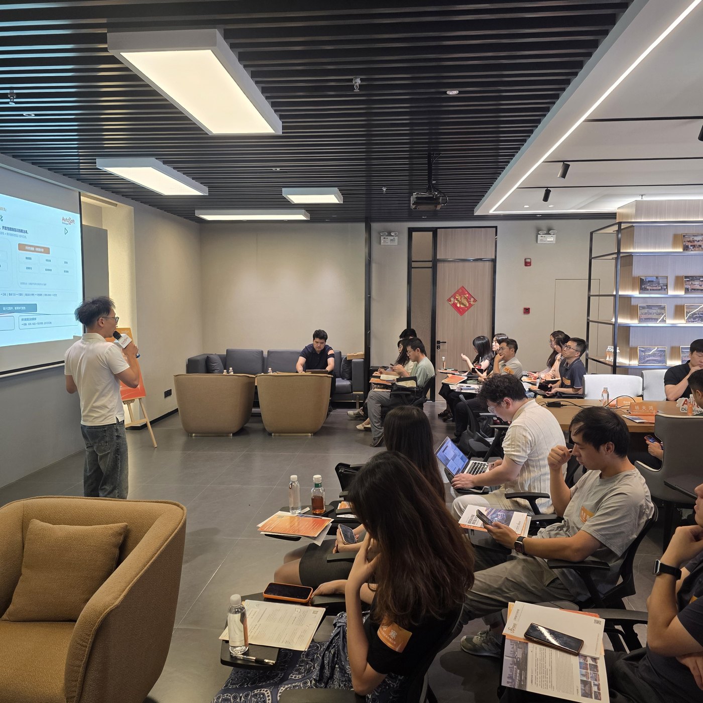 The room — attendees on sofas and chairs watching the presentation screen at the AutoSoft venue in Shanghai International Automobile City