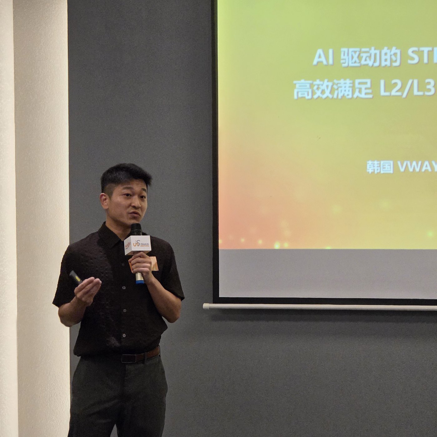 VWAY speaker presenting in front of the Chinese title slide “AI-driven STPA — meeting L2/L3/L4 efficiently”